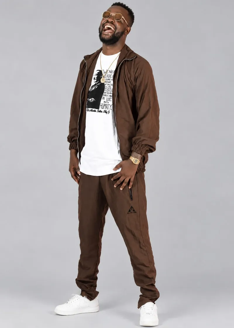 Brown track jacket and pants over a graphic tee