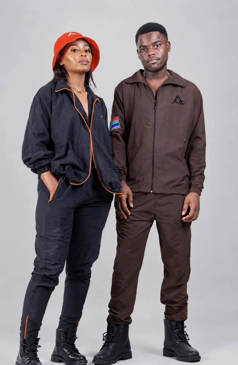 Duo in utility track sets — navy with orange piping and brown